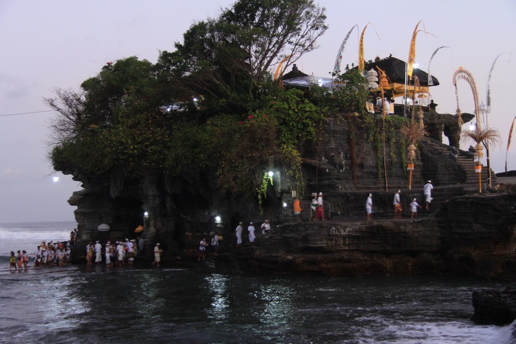 Бали. Верующие идут вброд на молитву в Танах Лот.